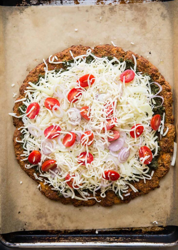 Arugula-topped pesto pizza made with grain-free sweet potato crust