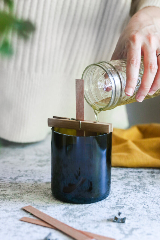 Pouring wax in wine bottle candle